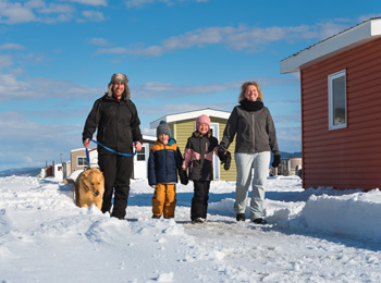 Une famille pratiquant la pêche sur glace aux Glaces du Fjord