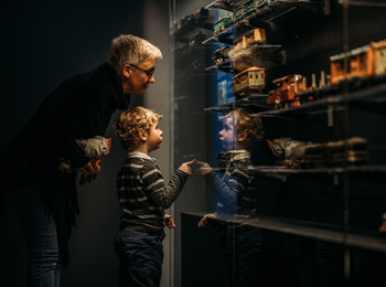 Jeune garçon et grand-parent regardant l'exposition de train miniatures
