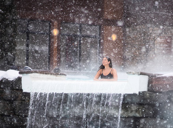 Femme en train de se baigner dans un bain thermal sous les flocons