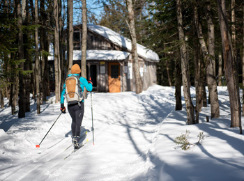 Fondeuse qui parcourt un sentier de ski de fond enneigé